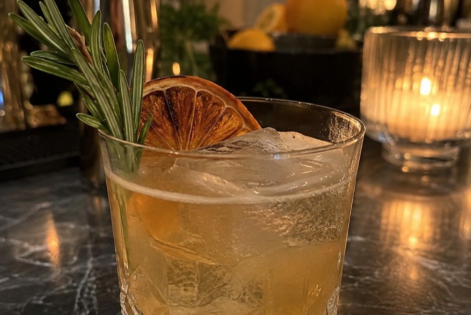 Rocks-glass signature cocktail with dehydrated orange and rosemary at a Dallas wedding bar